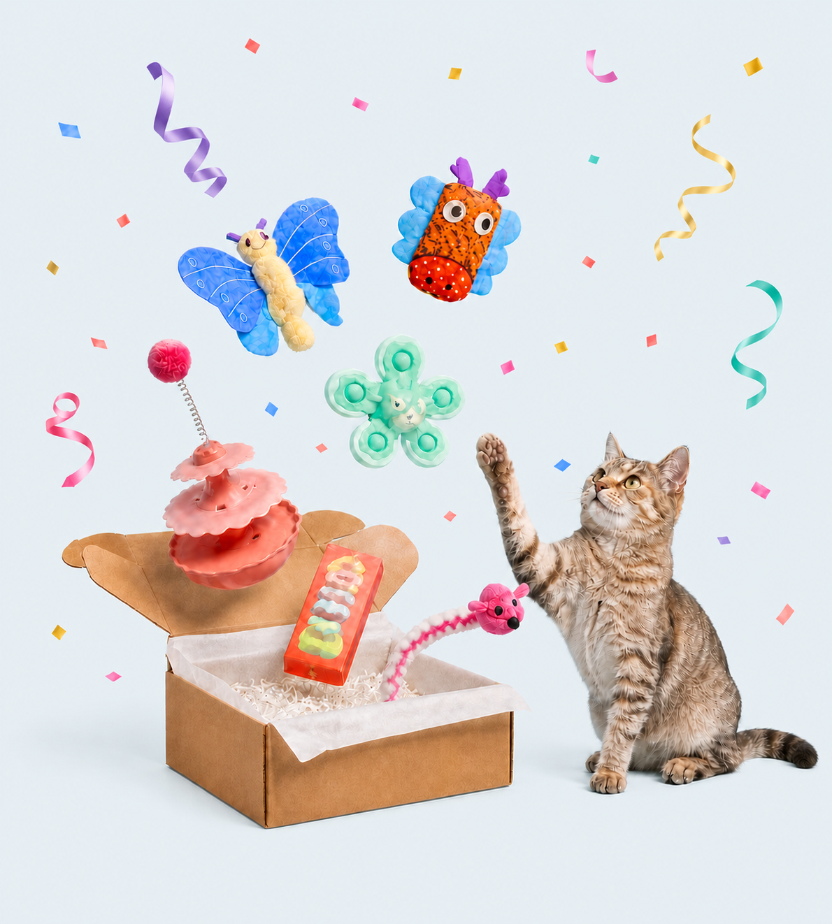 A cat discovering a MEWMORA surprise toy box surrounded by colorful toys and confetti